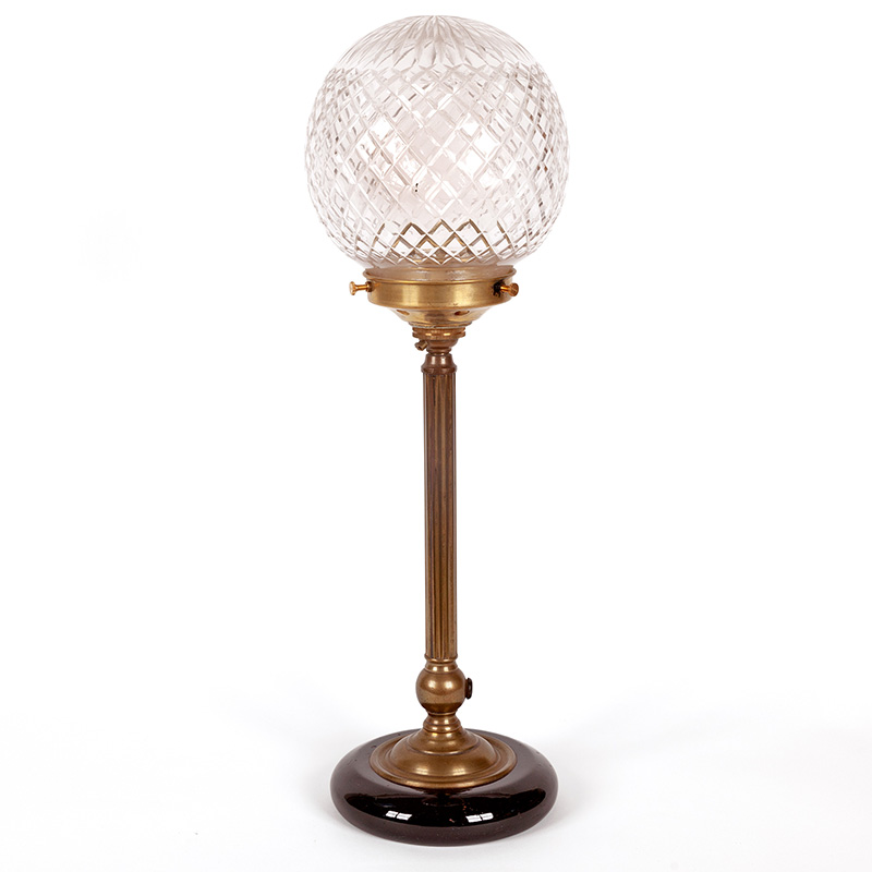 Late Edwardian brass table lamp on a black china base, reeded column fitted with a cut glass globe (c.1915)